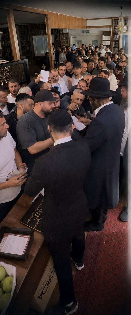 Autour du Rav, des fidèles lui remettent le papier portant leur nom pour le Pidyon Nefesh.
